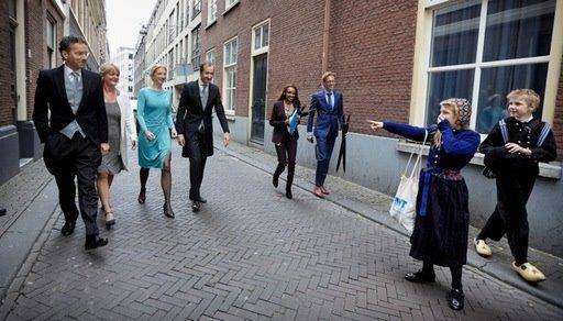 Toevallige ontmoeting van minister Jeroen Dijsselbloem en staatssecretaris Eric Wiebes en echtgenotes op Prinsjesdag op straat met twee jongeren in klederdracht (Martijn Beekman)