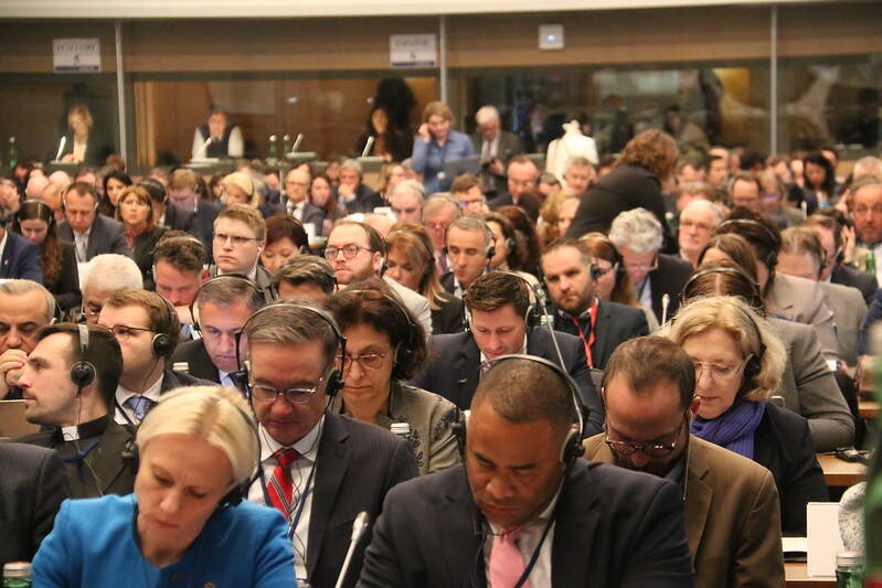 Foto van een vergaderzaal gevuld met leden van de parlementaire assemblee van de OVSE